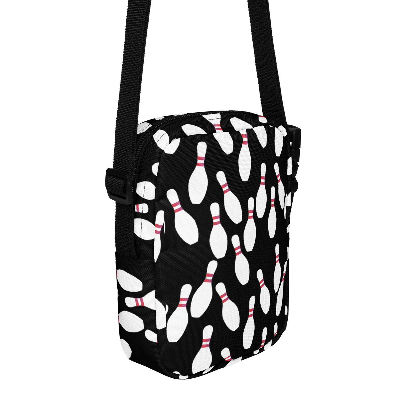 Black crossbody bag with white bowling pin pattern and adjustable strap.