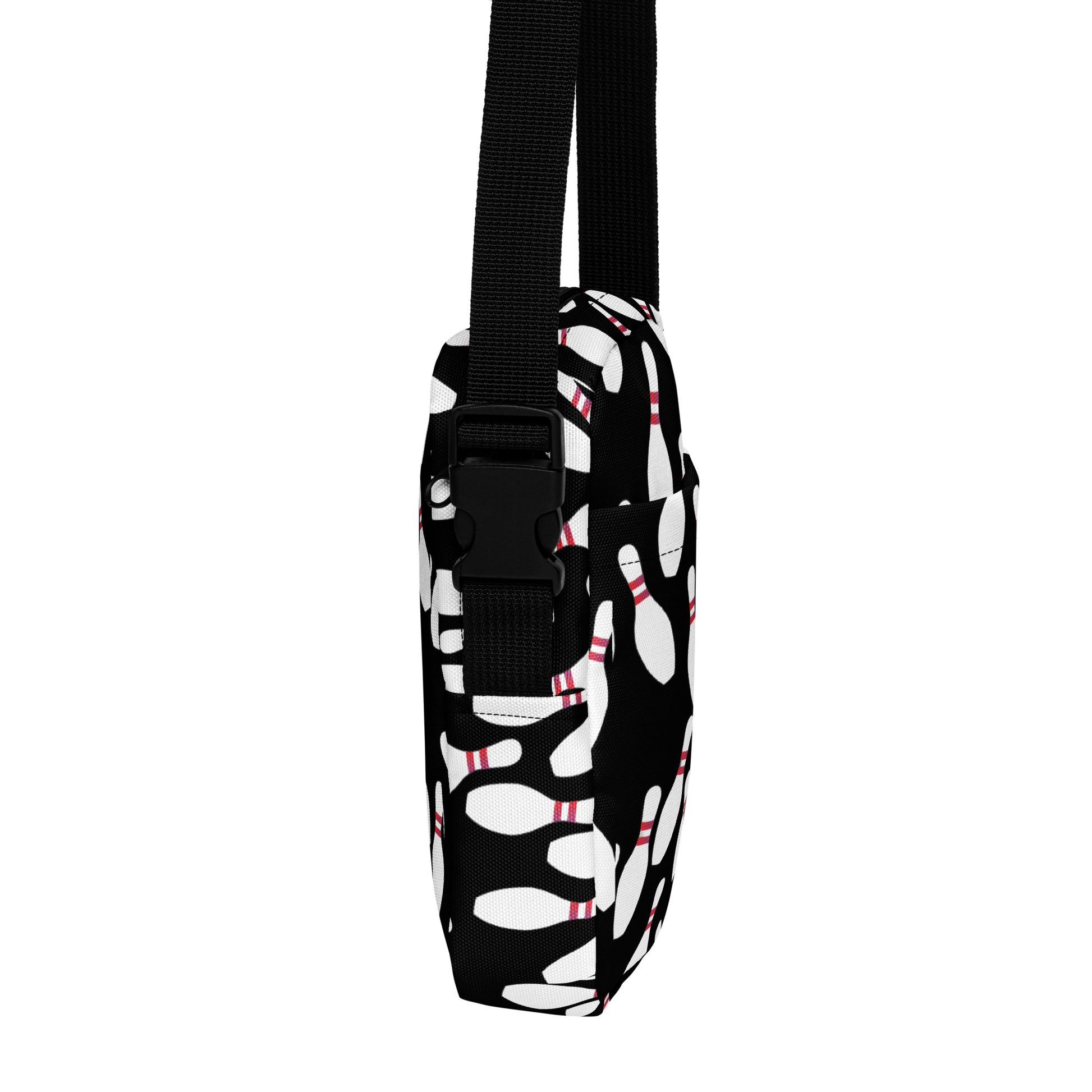 Black and white bowling pin patterned crossbody bag with adjustable black strap.